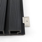 End view of hollow black composite cladding with a stainless steel installation bracket at the side