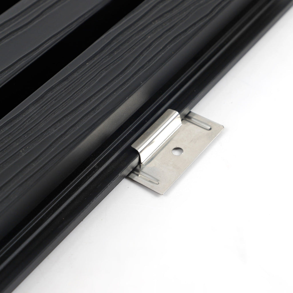 Close-up of stainless steel installation bracket clipped beneath the edge of black composite cladding