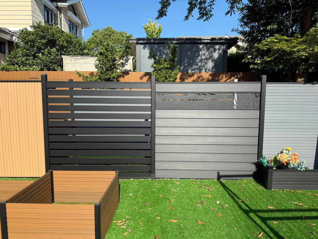 Modern composite fence panels in gray and black with horizontal slats installed in residential backyard