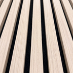 Close-up of natural oak acoustic slat wall panel with black felt backing