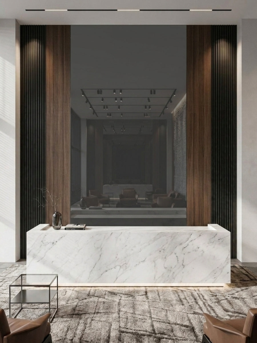 Gray mirror feature wall framed by vertical wood and black slatted panels behind a marble reception desk