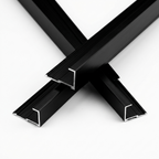 Three crossed black aluminum alloy end cap trim strips showing their channel-shaped ends