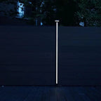 Vertical LED fence post light mounted on composite privacy fence at night