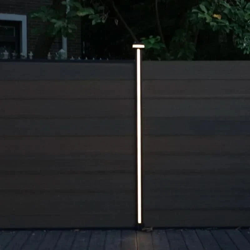 Vertical LED fence post light mounted on composite privacy fence for outdoor night illumination