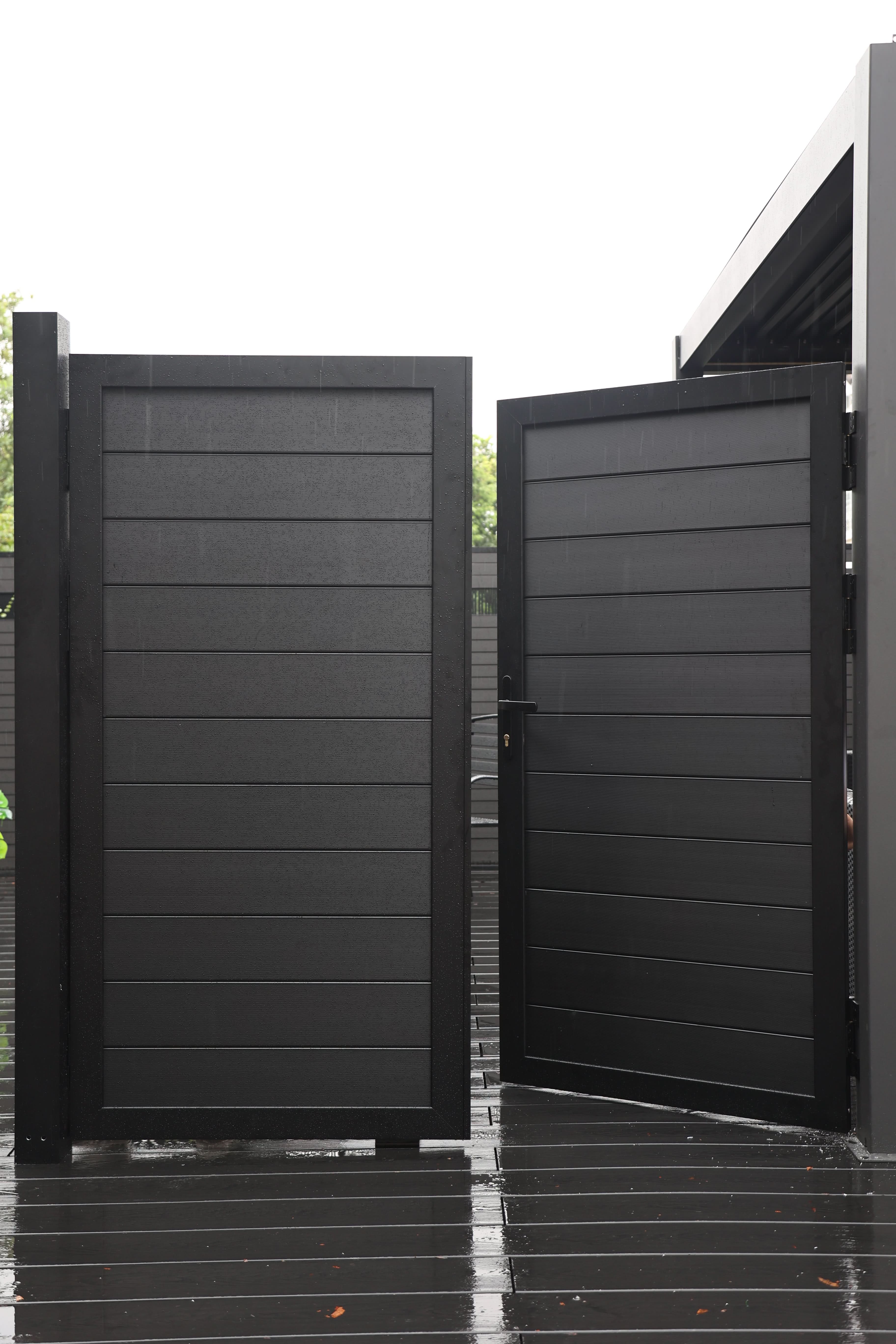 Black aluminum double privacy fence gate partially open with horizontal slat panels