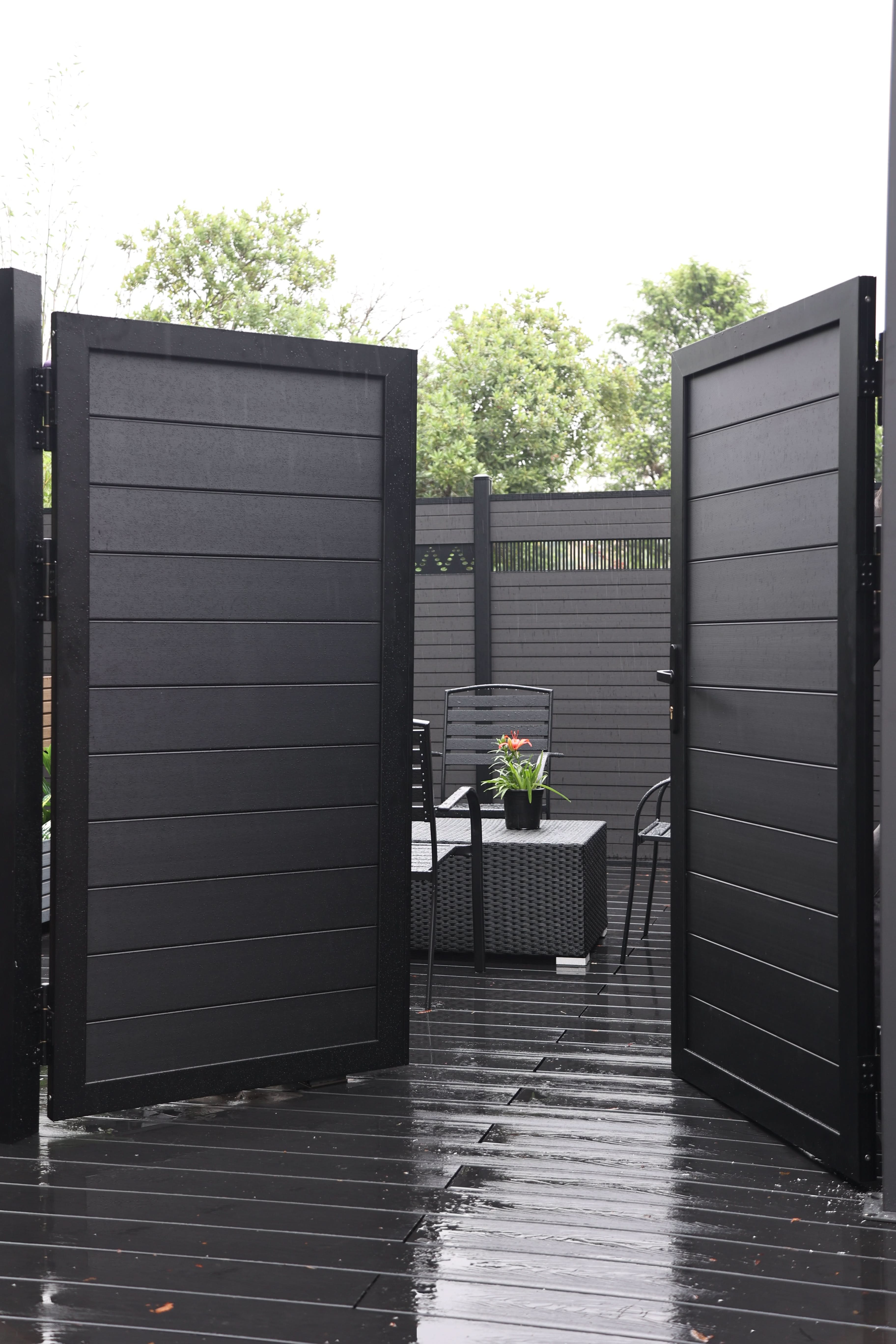 Black aluminum double privacy fence gate fully open with horizontal slat panels