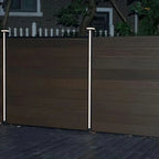 Composite privacy fence with vertical LED post lights installed between fence panels at night