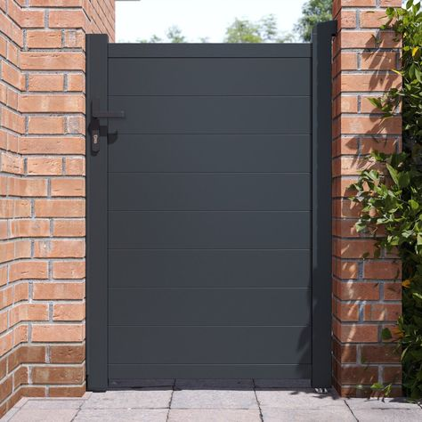Dark gray composite single fence gate with aluminum frame between brick pillars