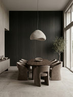 Dark Blackwood veneer wall panels forming a dining room accent wall behind a round table