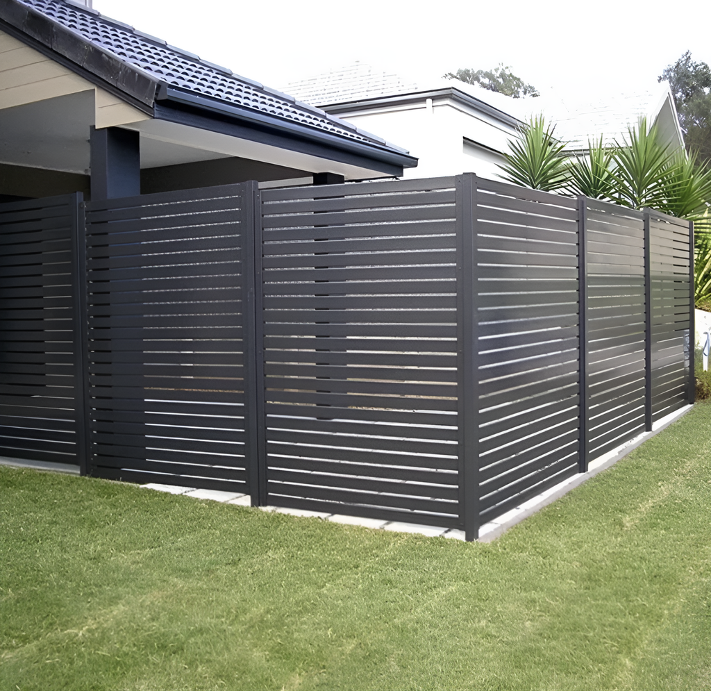 Dark gray composite horizontal slat privacy fence enclosing modern residential backyard