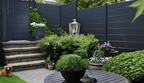 Dark gray composite horizontal privacy fence installed in landscaped residential garden patio