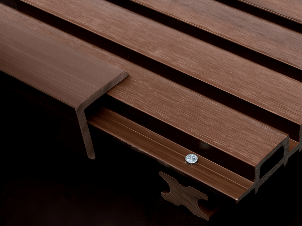 Close-up of brown WPC fluted wall panel with wood grain finish and mounting clip
