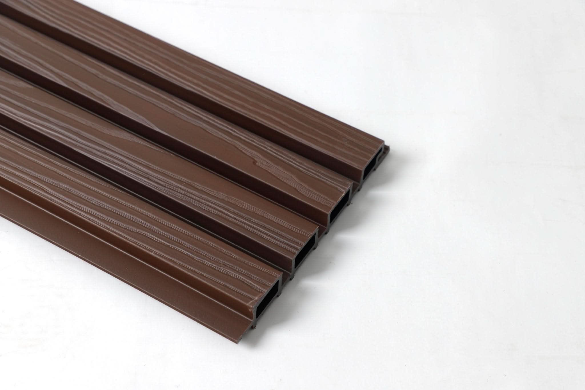 Brown WPC fluted wall panel boards with wood grain finish, angled view