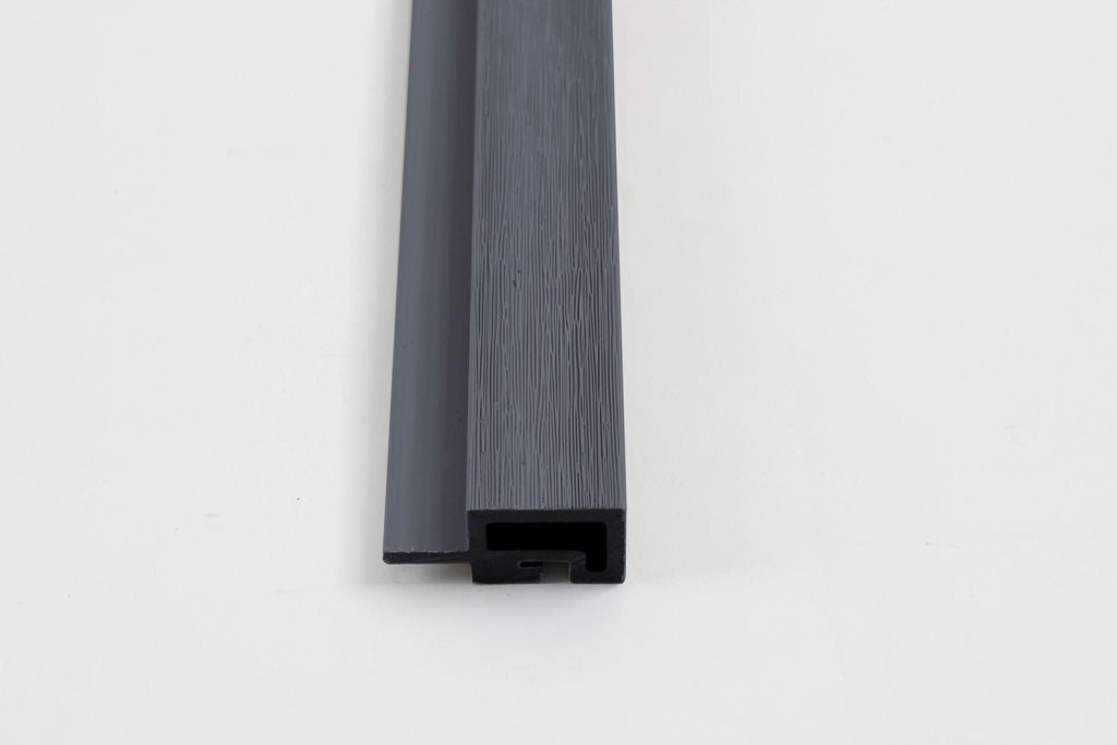 Dark gray composite trim end view with wood grain texture and channel design