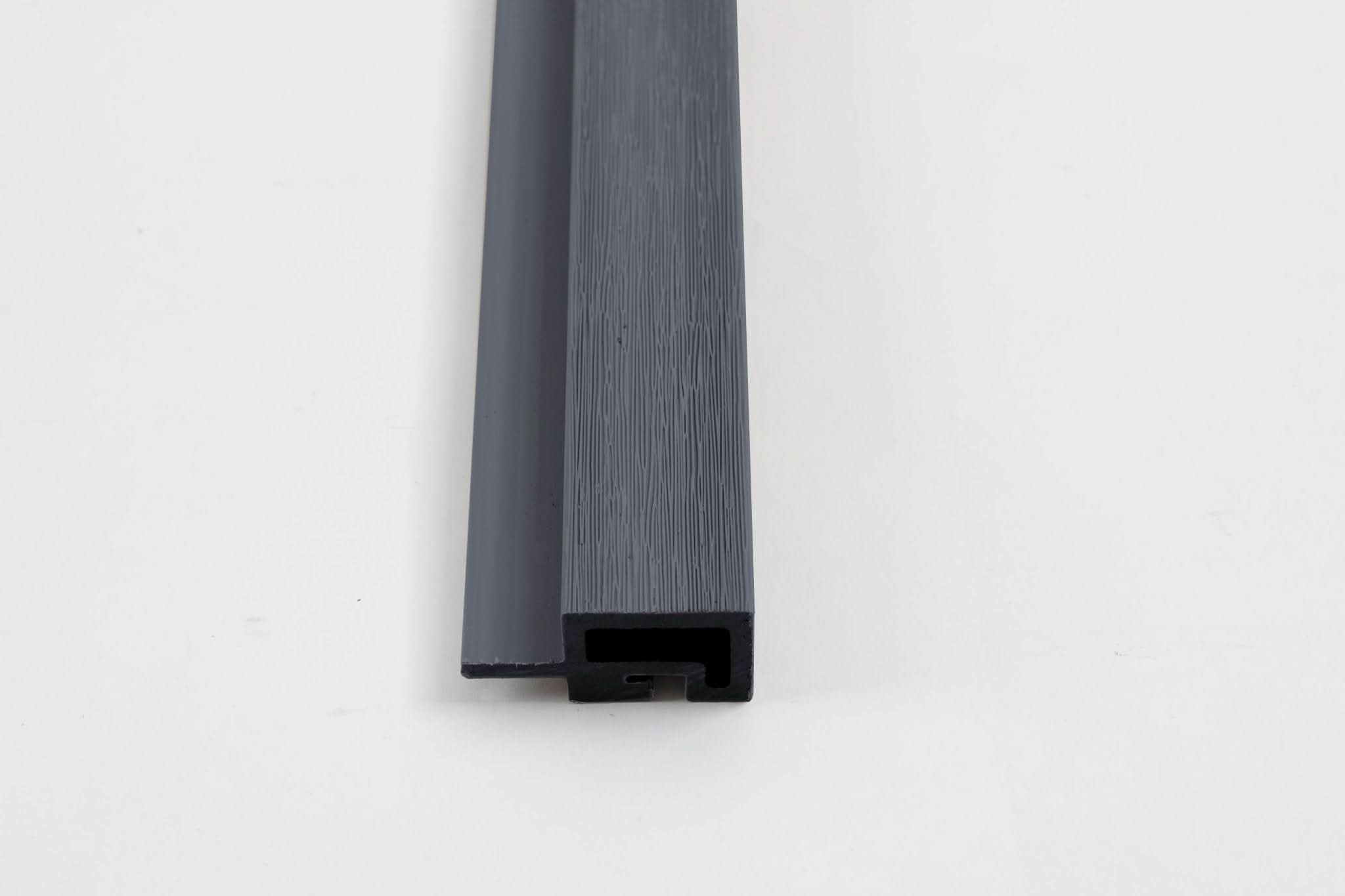 Dark gray composite trim end view with wood grain texture and channel design