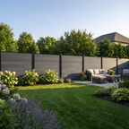 Light gray composite fence installed behind a garden lawn and outdoor seating area