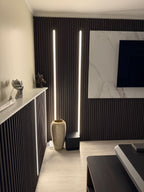 Vertical recessed LED strip lighting on fluted wall panels for modern TV feature wall
