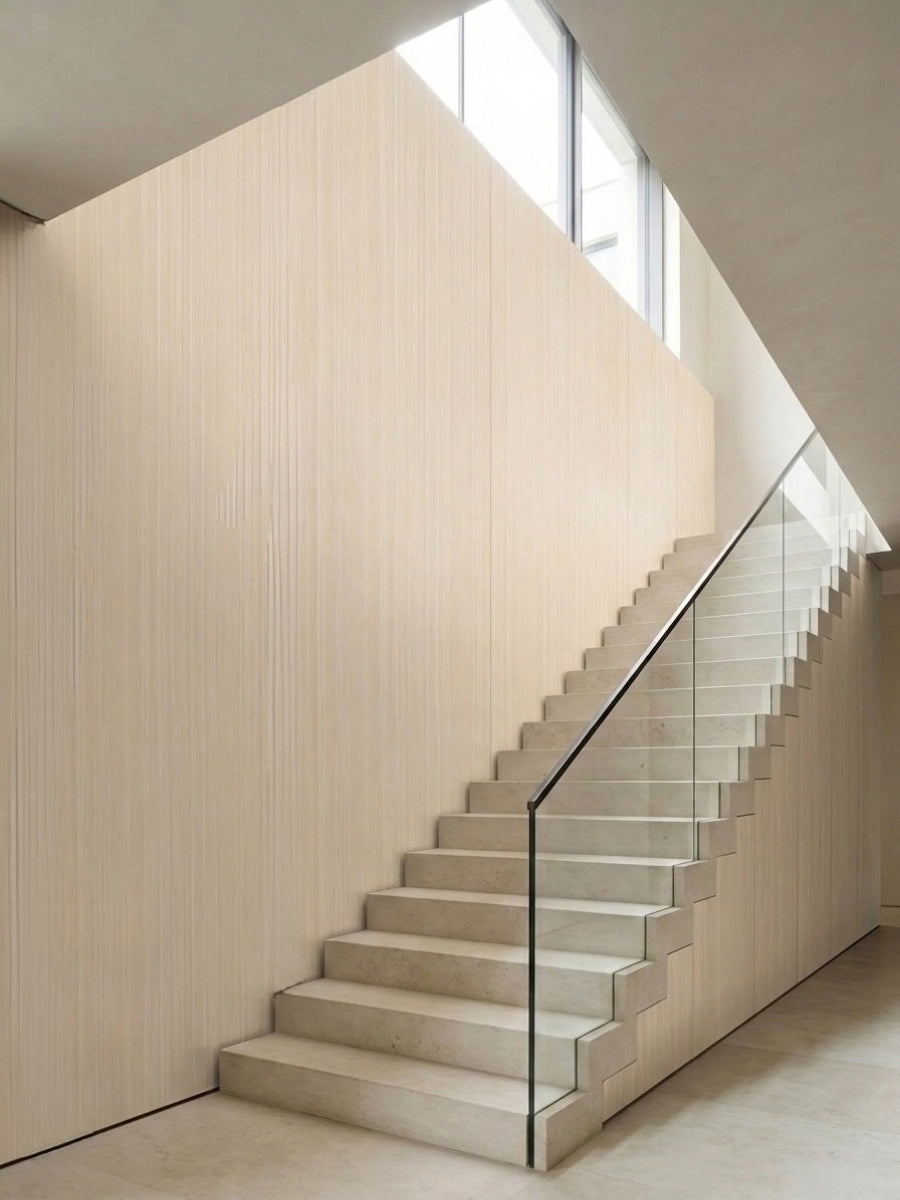 Nordic birch wood veneer panels covering a tall stairwell wall beside a glass-railed staircase
