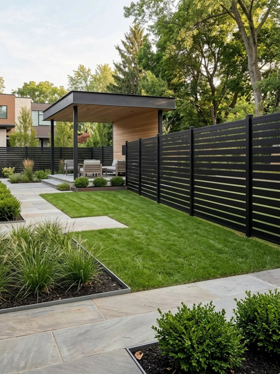 Black aluminum open slat fence enclosing a landscaped backyard lawn and covered patio