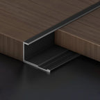 Black aluminum wall panel trim end cap installed on wood panels, durable metal edge strip for clean panel edges and modern interior wall finishing