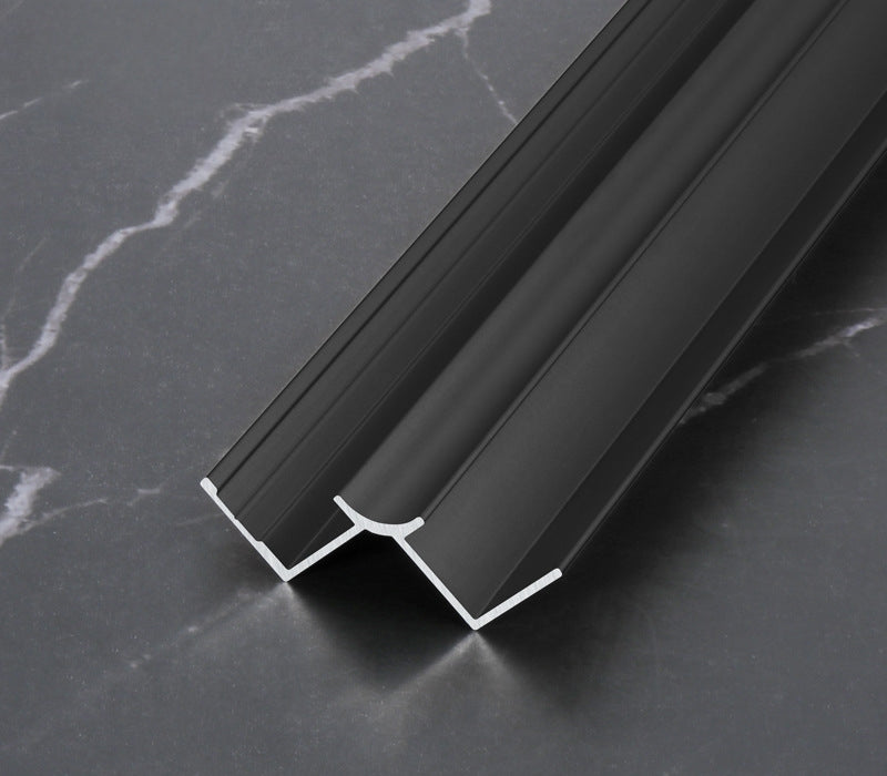 Black 3mm aluminum inside corner trim profile in close-up on dark marble