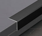 Black aluminum L cap trim fitted over the edge of a dark wall panel