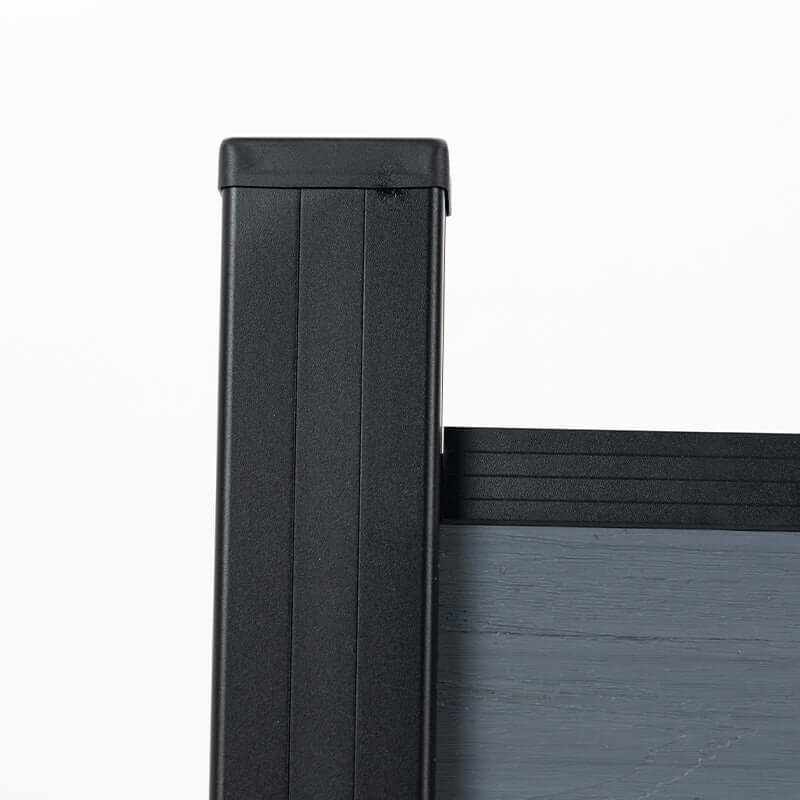 Close-up of a black capped post and top rail on the light gray composite fence