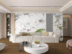 Modern living room with white marble wall panels, neutral furniture, and wood flooring
